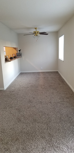 Gautier apartment for rent - an empty living room with carpet and a ceiling fan