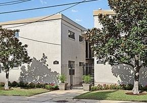 New Orleans apartment for rent - a building with a gate and trees in front of it