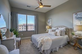 Sun Prairie apartment for rent - a bedroom with a large bed and a ceiling fan