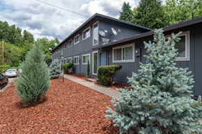 Portland apartment for rent - a blue house with a gravel driveway and trees