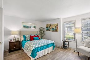 Ponte Vedra Beach apartment for rent - A bedroom with a bed, nightstand, chair, and two lamps.