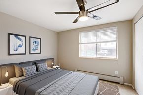 Denver apartment for rent - a bedroom with a large bed and a ceiling fan