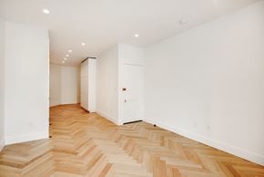 Brooklyn apartment for rent - a renovated living room with a wooden floor and white walls
