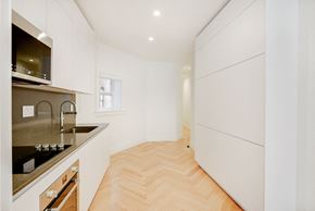 Brooklyn apartment for rent - a kitchen with white cabinets and a wood floor