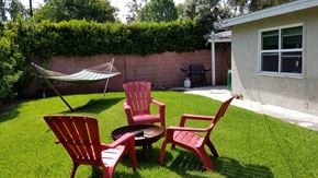 Newport Beach apartment for rent - a backyard with chairs and a table and a hammock