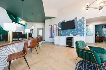 Phoenix apartment for rent - A modern living room with a green chair and a television on the wall.