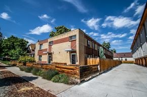 Denver apartment for rent - the exterior of a brick building with a wooden fence