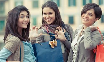West New York apartment for rent - Three women are standing together, each holding a shopping bag.