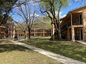 San Antonio apartment for rent - the courtyard of a building with trees and a sidewalk