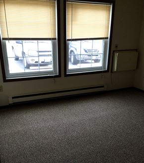 Galena apartment for rent - an empty room with three windows and a car parked outside