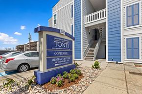 Metairie apartment for rent - a building with a sign in front of a parking lot