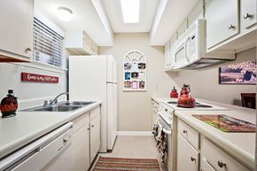 Metairie apartment for rent - A kitchen with white cabinets and a sink.