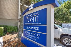 Metairie apartment for rent - A blue and white sign for Tonti Apartment Homes stands in front of a building.