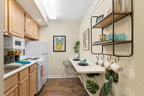 Metairie apartment for rent - A kitchen with wooden cabinets and a white refrigerator.