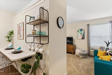 Metairie apartment for rent - A living room with a blue couch and a white dining table.