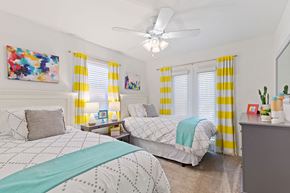 Metairie apartment for rent - A bedroom with two beds and a ceiling fan.