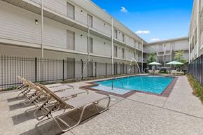 Metairie apartment for rent - A pool surrounded by sun loungers in a sunny courtyard.