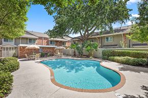 Metairie apartment for rent - A swimming pool surrounded by a concrete patio and residential houses.