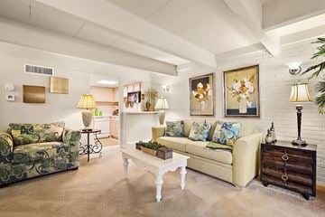 Metairie apartment for rent - A living room with a white couch and a green patterned chair.