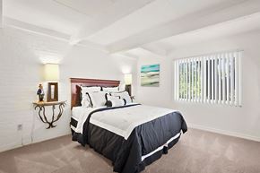 Metairie apartment for rent - A bedroom with a large bed and a painting on the wall.