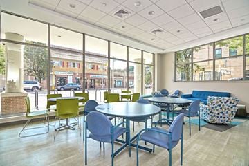 Boston apartment for rent - a lounge area with tables and chairs and large windows