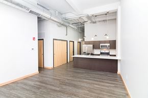 Sioux City apartment for rent - an empty room with a kitchen and white walls and wood floors