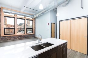 Sioux City apartment for rent - a kitchen with a large window and a white counter top and a sink
