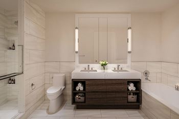 Custom wood paneled vanities with caesarstone countertops