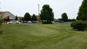 Delavan apartment for rent - a lawn in front of a parking lot