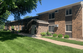 Stoughton apartment for rent - a brick apartment building with a lawn and a sidewalk