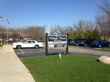 Paddock Lake apartment for rent - a sign for village pizza in front of a parking lot
