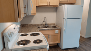 Cuba City apartment for rent - A white stove with four burners is in a kitchen with a white refrigerator.