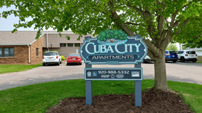 Cuba City apartment for rent - A sign for Cub City Apartments is displayed in front of a tree.