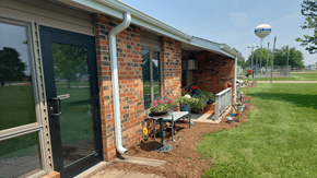 Cuba City apartment for rent - A brick house with a black door and a white pipe on the side.
