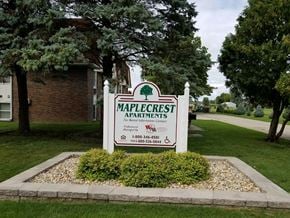 Wataga apartment for rent - the sign for maple crest apartments in front of a lawn and trees