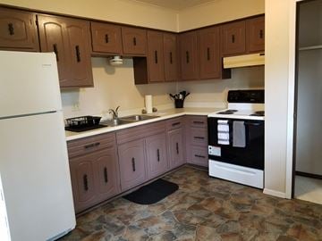 Wataga apartment for rent - a kitchen with white appliances and wooden cabinets