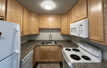 Sauk City apartment for rent - a kitchen with white appliances and granite counter tops and wooden cabinets