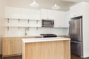 Chicago apartment for rent - a kitchen with white cabinets and a stainless steel refrigerator