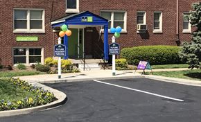 Indianapolis apartment for rent - a parking lot in front of a building with signs and balloons