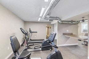 Indianapolis apartment for rent - a gym with some exercise machines and a table