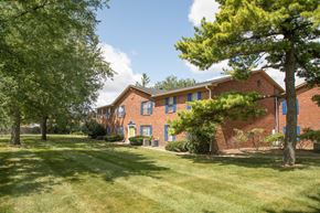 Indianapolis apartment for rent - the front of a brick apartment building with grass and trees