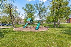 Indianapolis apartment for rent - a playground with a green swing set in a park
