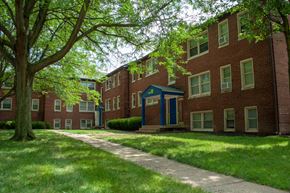 Indianapolis apartment for rent - a sidewalk in front of a red brick apartment building