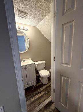 Calhoun apartment for rent - A bathroom with a toilet, sink, and mirror.