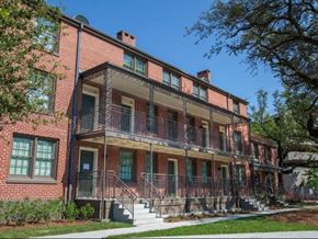 New Orleans apartment for rent - a red brick house with a porch and stairs