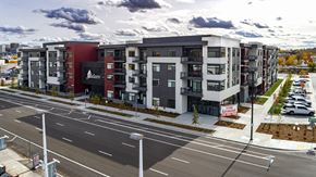 Boise apartment for rent - A street view of a multi-story building with a red and white sign that reads "Ballard".
