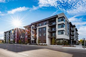 Boise apartment for rent - A modern apartment building with a bright sun in the background.
