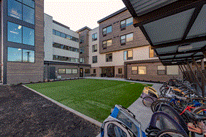 Boise apartment for rent - a courtyard with a lawn and bikes parked in front of a building