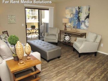 Modesto apartment for rent - A living room with a couch, chair, ottoman, and a painting on the wall.