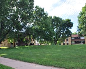 Mankato apartment for rent - a lawn in front of a building with trees
